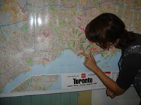 A woman places arrows on a map of Toronto