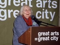 Jane Jacobs stands at a podium