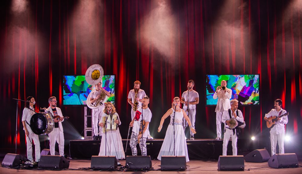 Lemon Bucket Orkestra dressed in white performing on stage