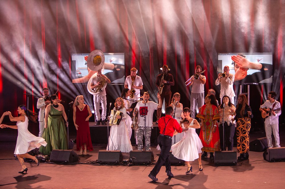 Lemon Bucket Orkestra performing on stage with Hit and Run dancers