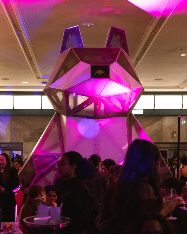 A massive installation of a wolf is seen at a dinner party