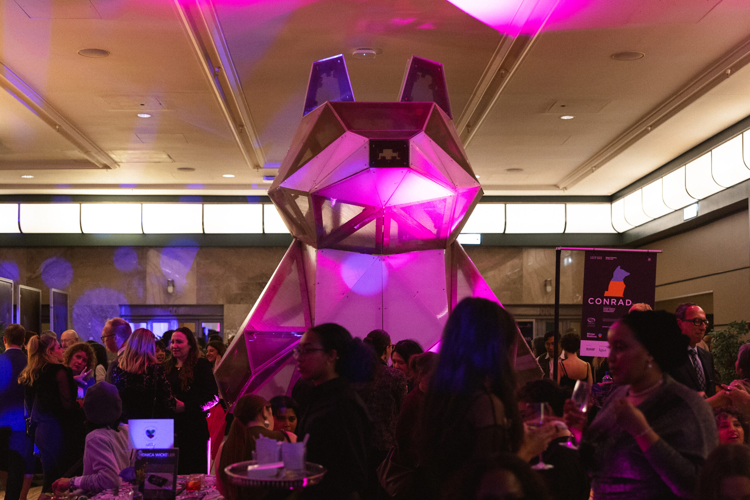 A massive installation of a wolf is seen at a dinner party