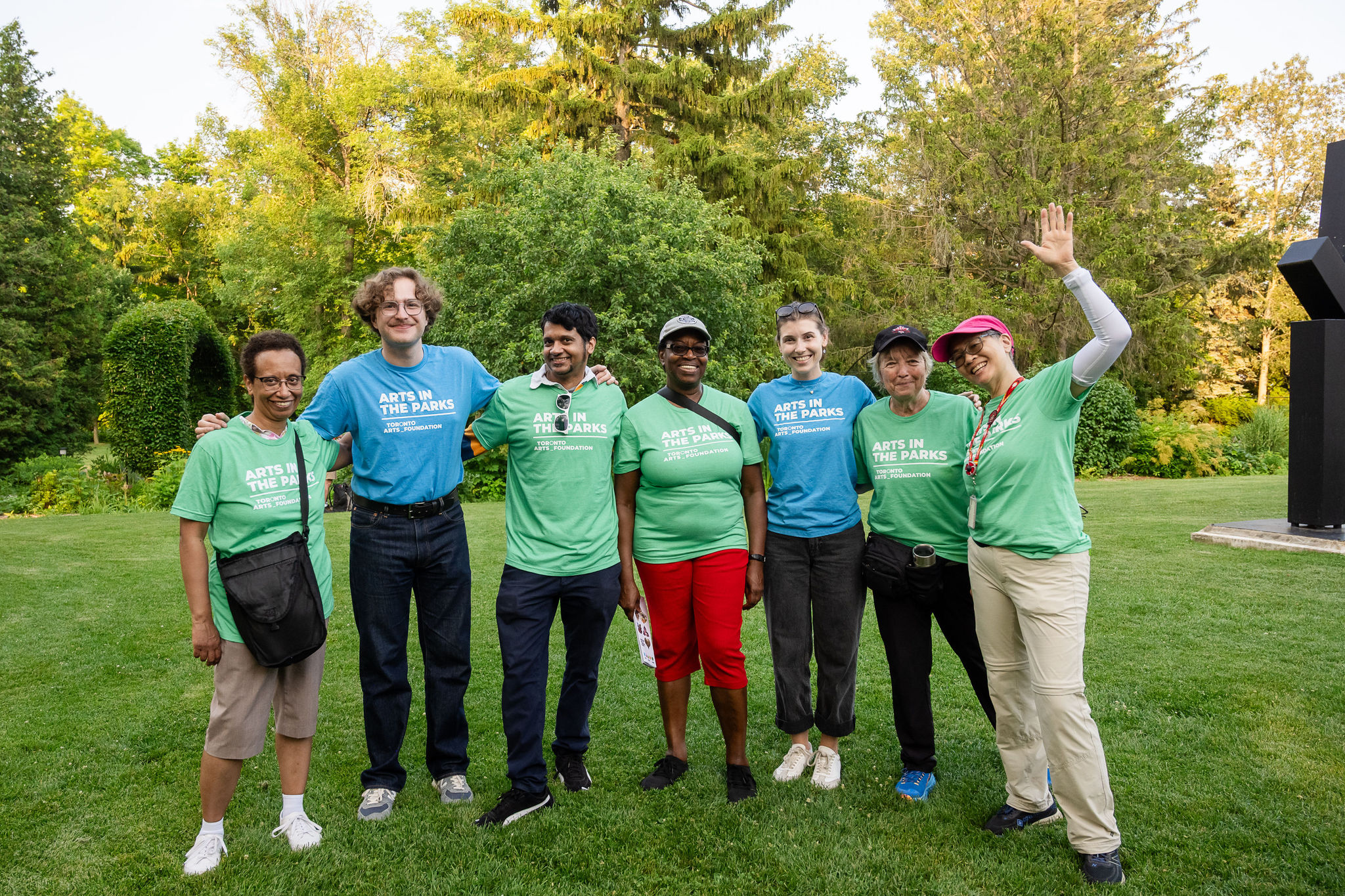 Arts in the Parks volunteers smile and wave at the camera.
