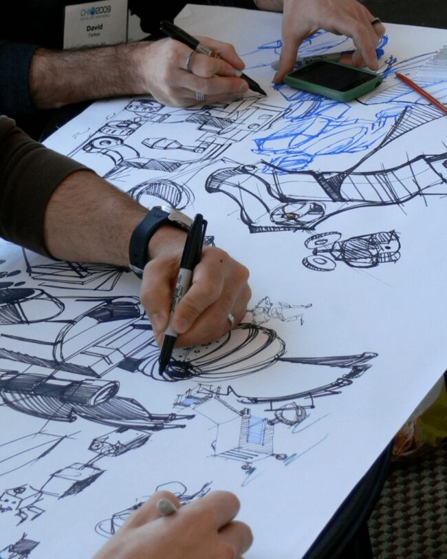People draw on a large paper.