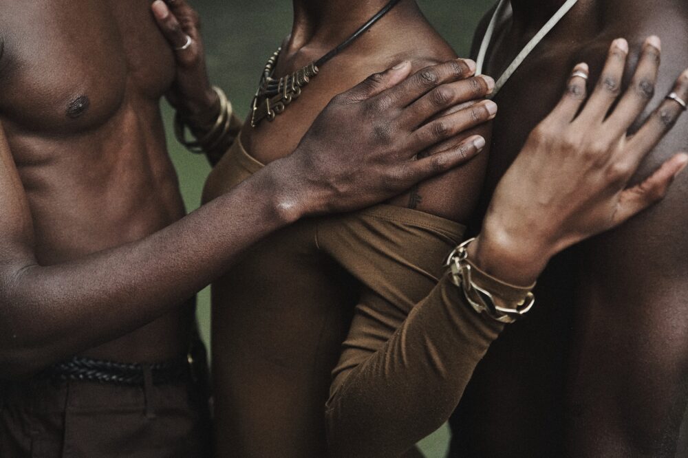 Three people rest their hands on each other.
