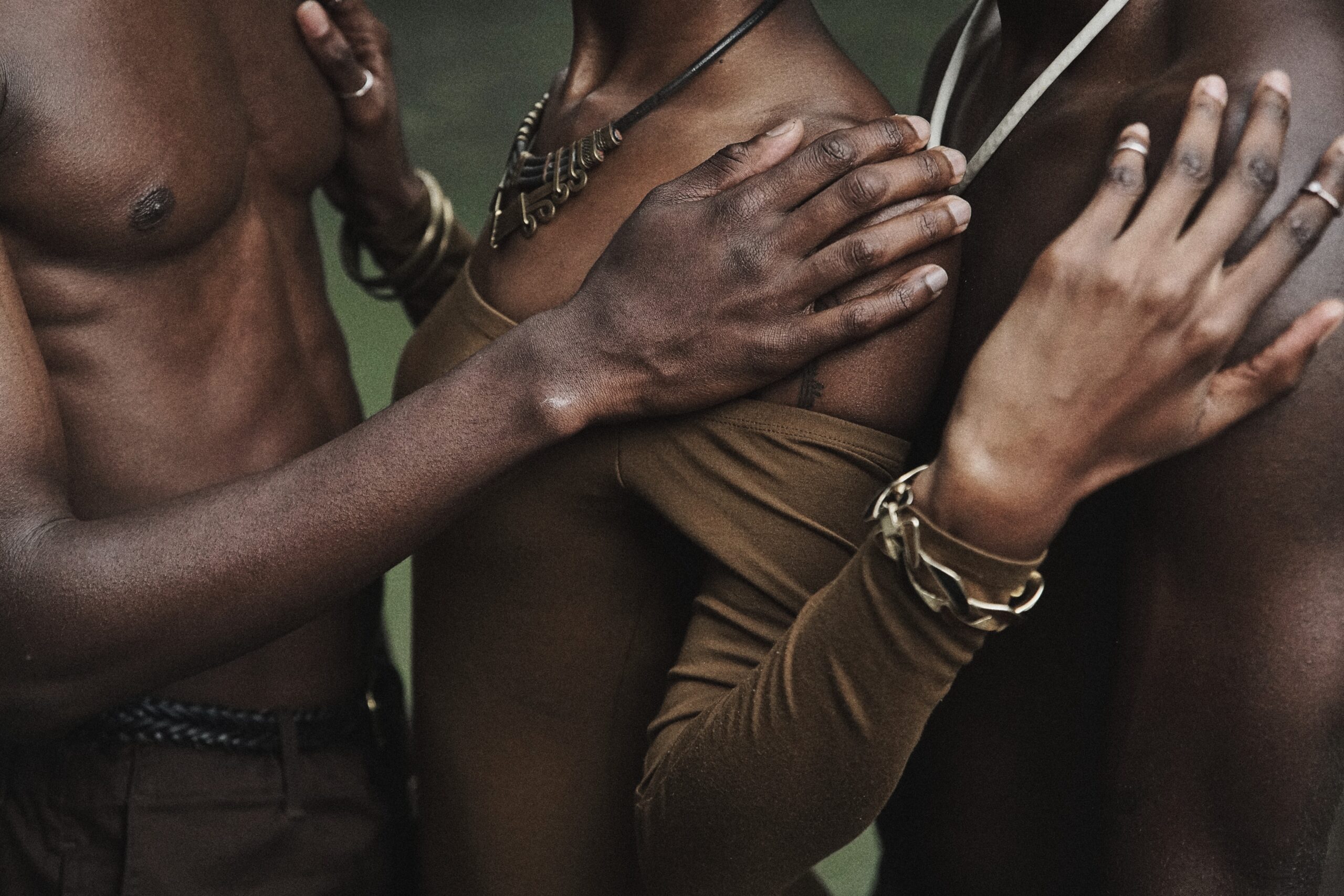 Three people rest their hands on each other.