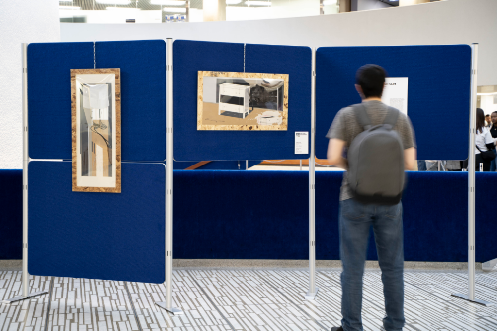 A person with a backpack looks at art in an exhibit.