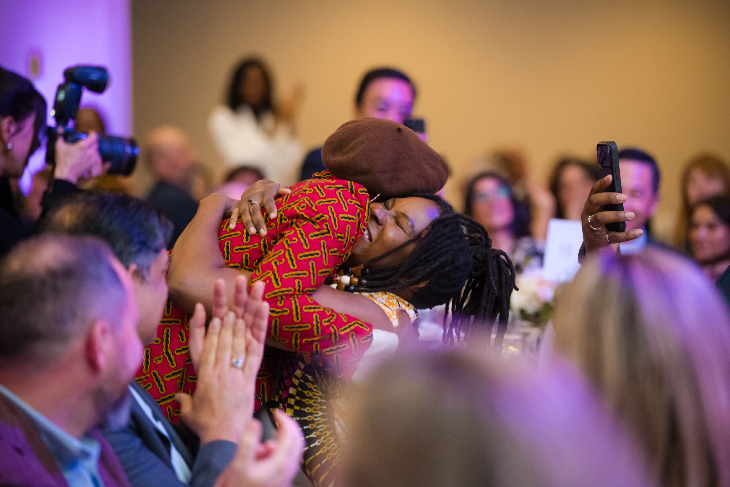 Dr. d’bi.young anitafrika hugs someone after winning an award.