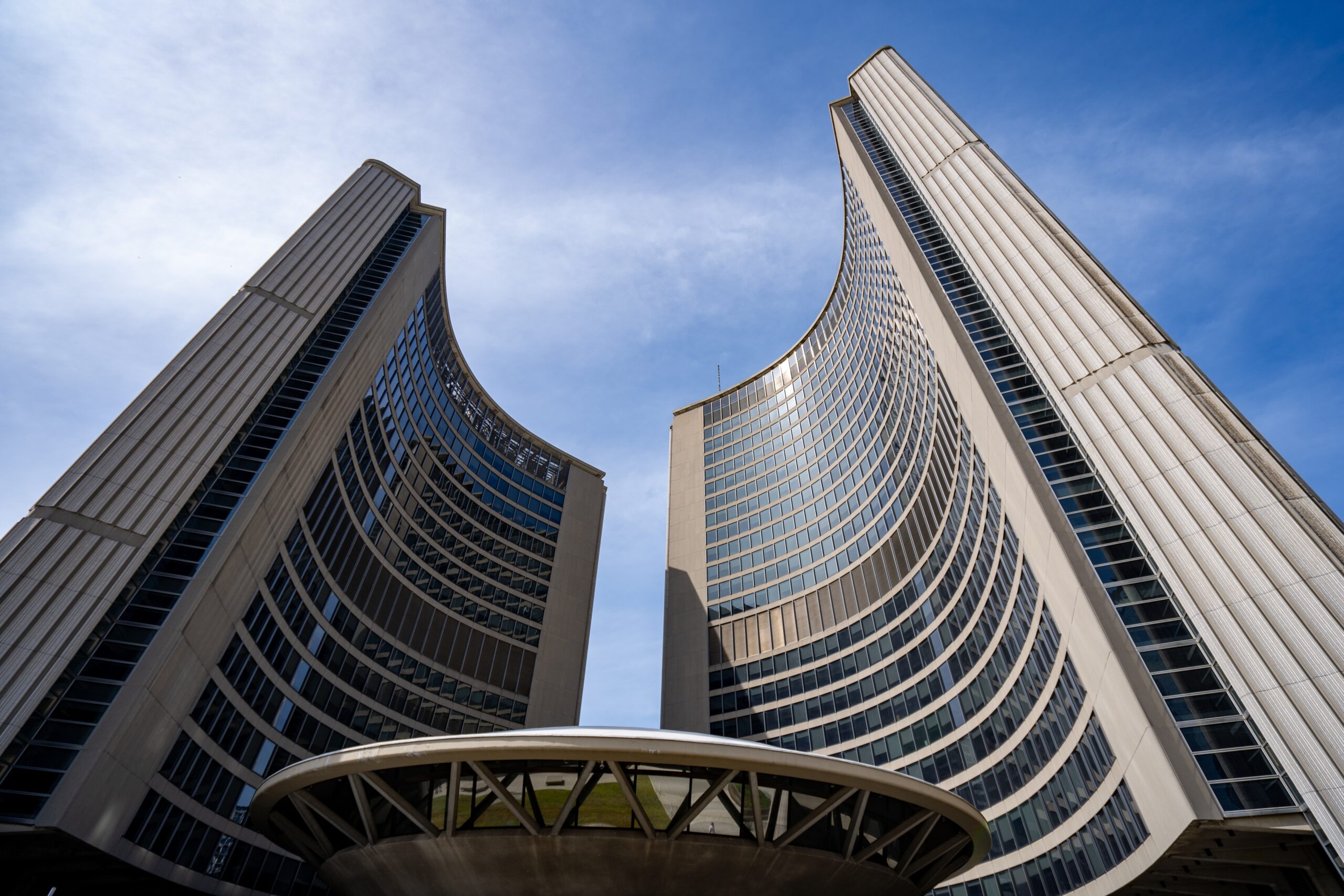 The two towers of city hall are pictured against a sunny blue sky.